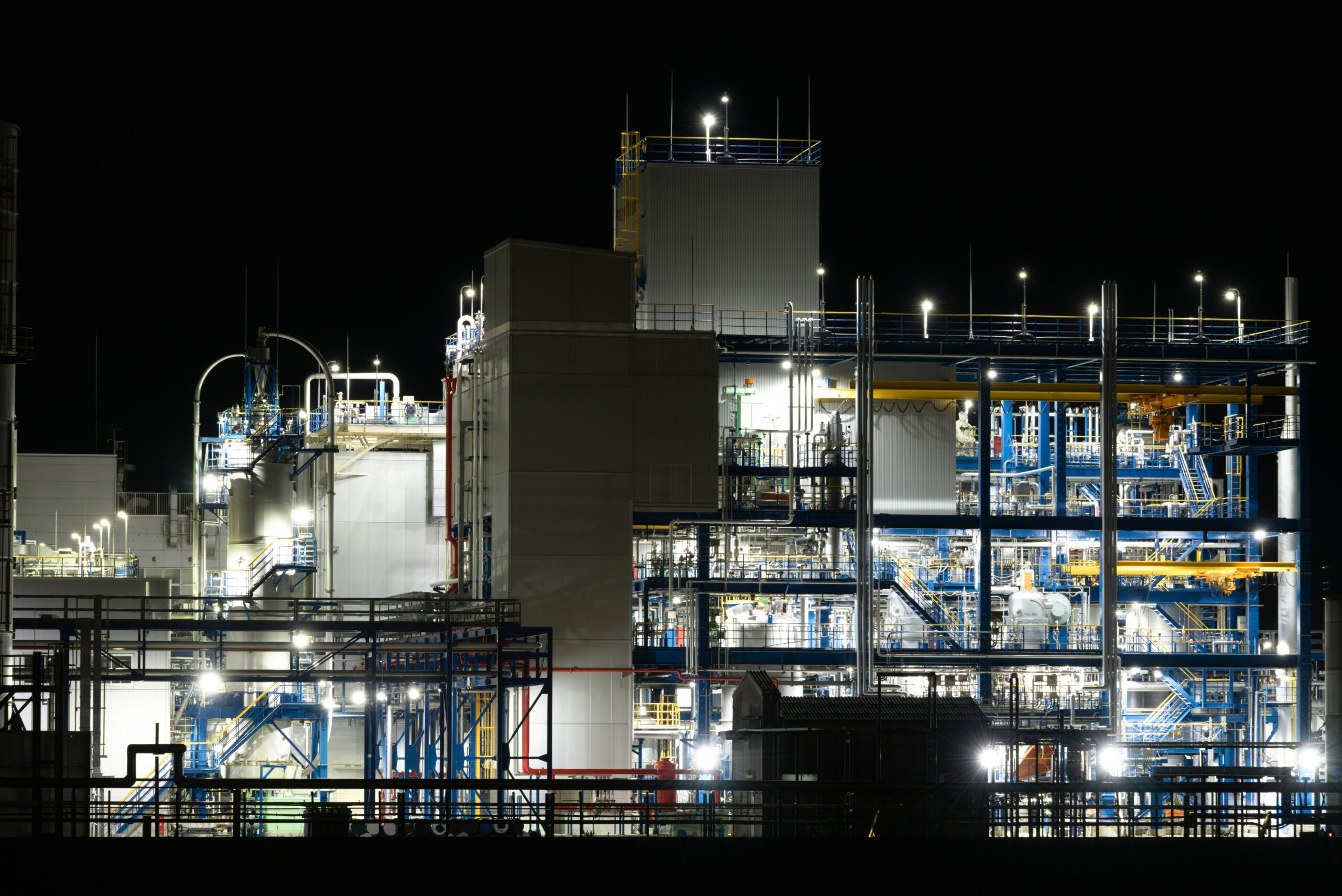 Industrial plant illuminated at night with complex machinery