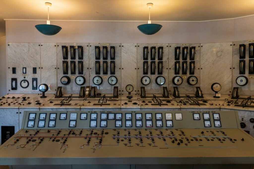 Industrial control room with monitoring displays showing facility power consumption and demand