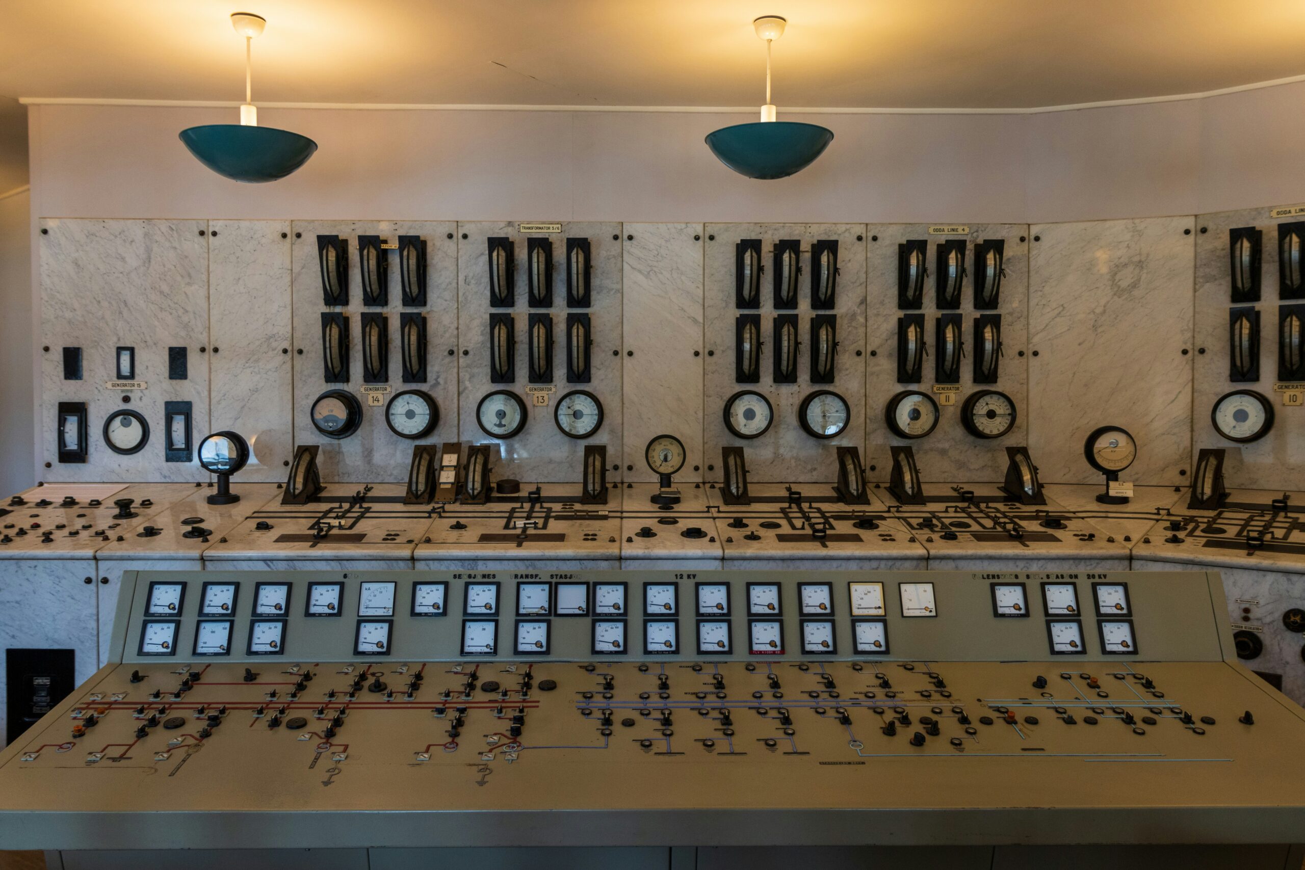 Industrial control room with monitoring displays showing facility power consumption and demand