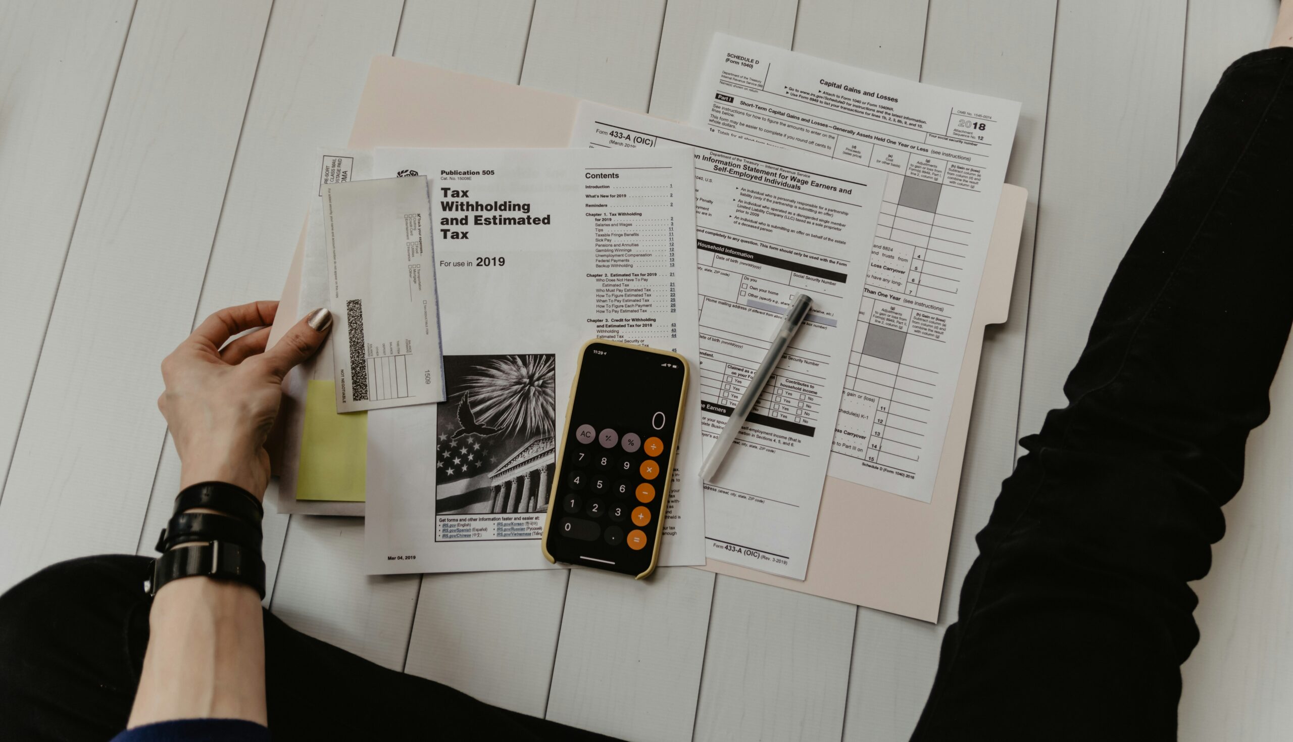 Person auditing utility bills with a calculator to identify overpayments and recoverable refunds